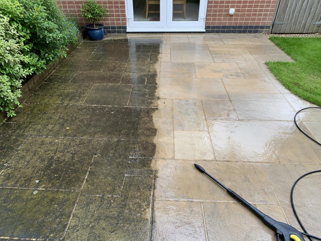 Patio jet washing in progress — half the slabs cleaned bright, half still dirty